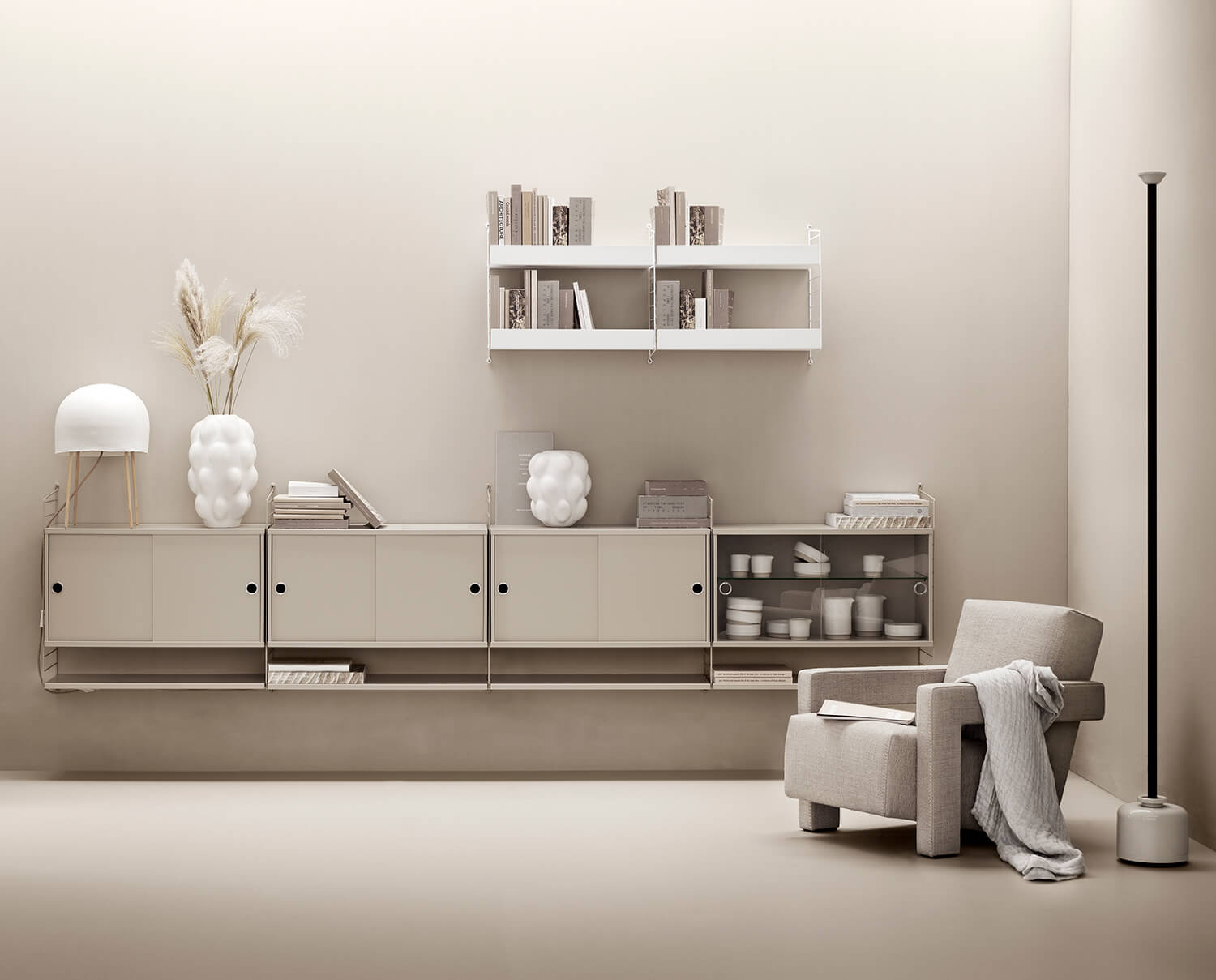 Stringhylder i beige og hvid i en afklebet stue.