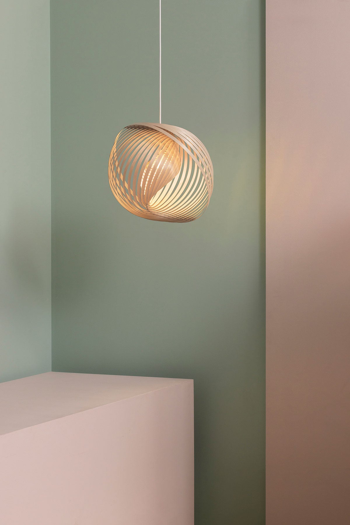 Adilo Small 8201 Loftlampe i birk, der hænger mod en lysegrøn og lyserød væg
