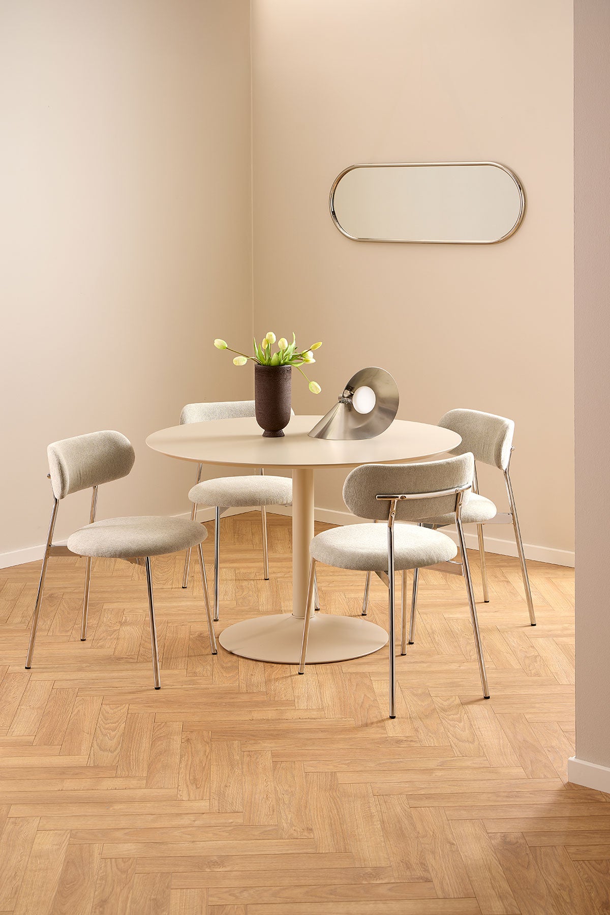 Ibiza Spisebord i beige MDF med fire spisebordsstole. Spisebordet er dekoreret med en vase og en bordlampe.